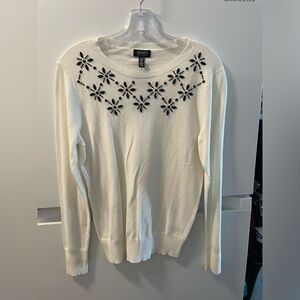 Long sleeve off-white sweater, crewneck with black detailing. Big for its size